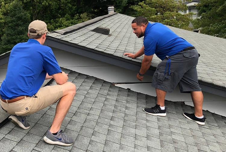 Friendly Waya roofing crew in front of a customer's home